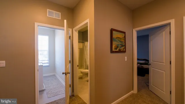 a view of a hallway with wooden floor and closet