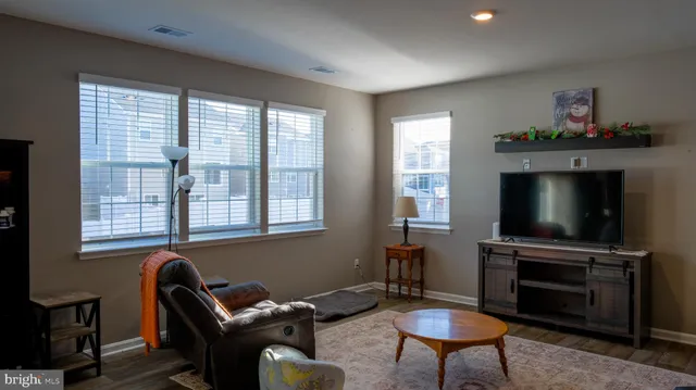 a living room with furniture a flat screen tv and a window