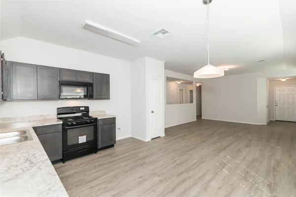 a kitchen with stainless steel appliances granite countertop a refrigerator and a stove top oven