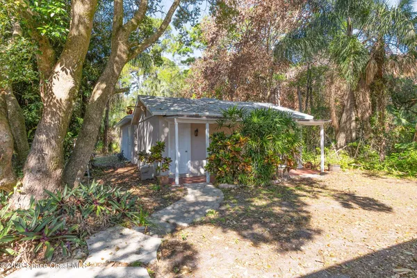 a view of a house with backyard and a tree