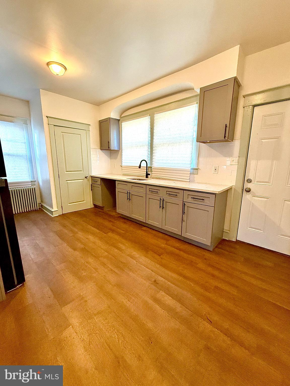 109-111 State Street Penns Grove, NJ 08069 - Photo 6 of 20 a large white kitchen with wooden floor and cabinets