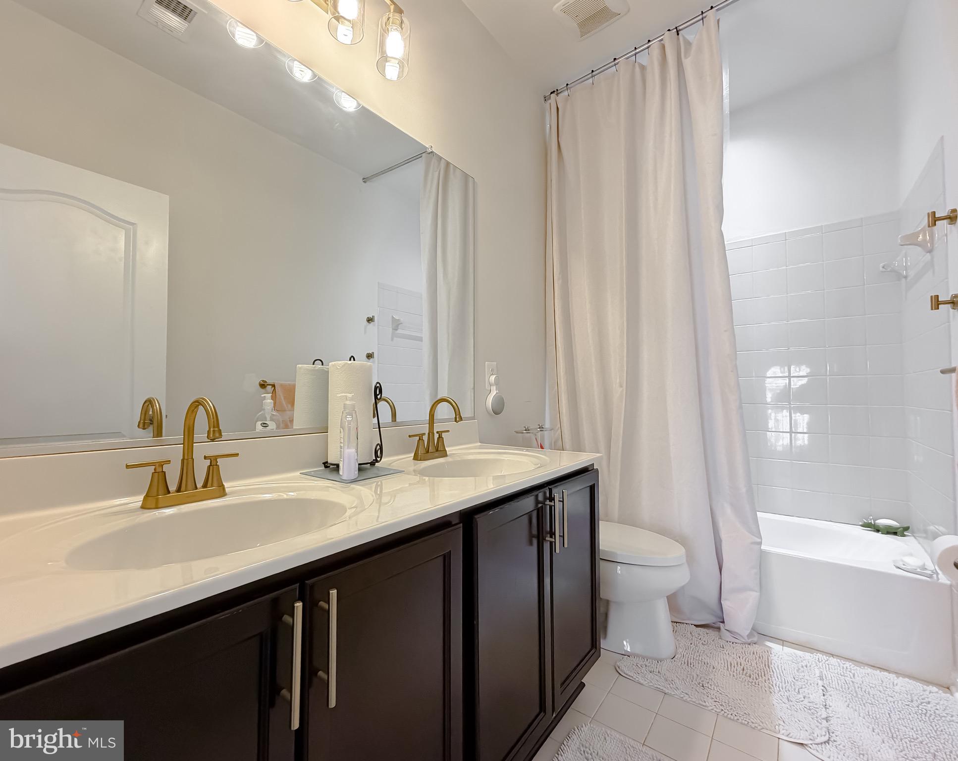 2810 Pumpkin Street Clinton, MD 20735 - Photo 19 of 27 a bathroom with a double vanity sink a toilet and a bathtub