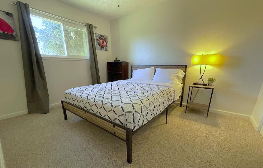 698 West Ashcroft Avenue Clovis, CA 93612 - Photo 8 of 11 a bedroom with a bed and a lamp