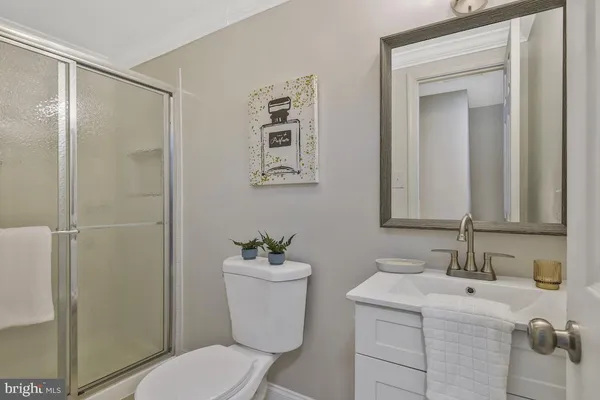 a bathroom with a toilet sink vanity and shower