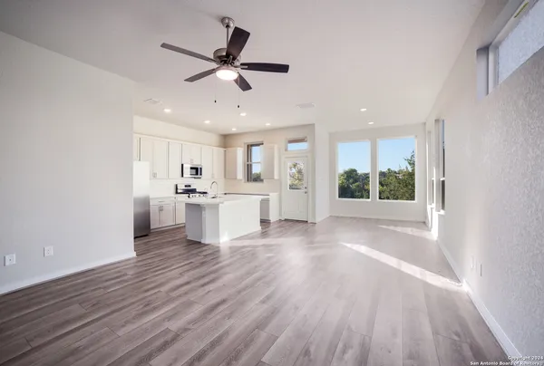 a view of a kitchen with wooden floor and a window
