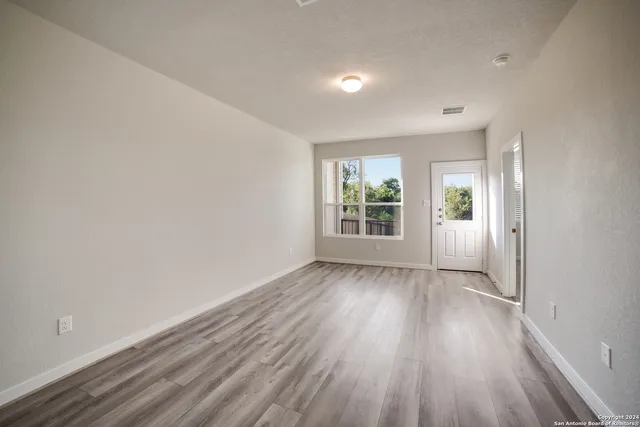 wooden floor in an empty room with a window