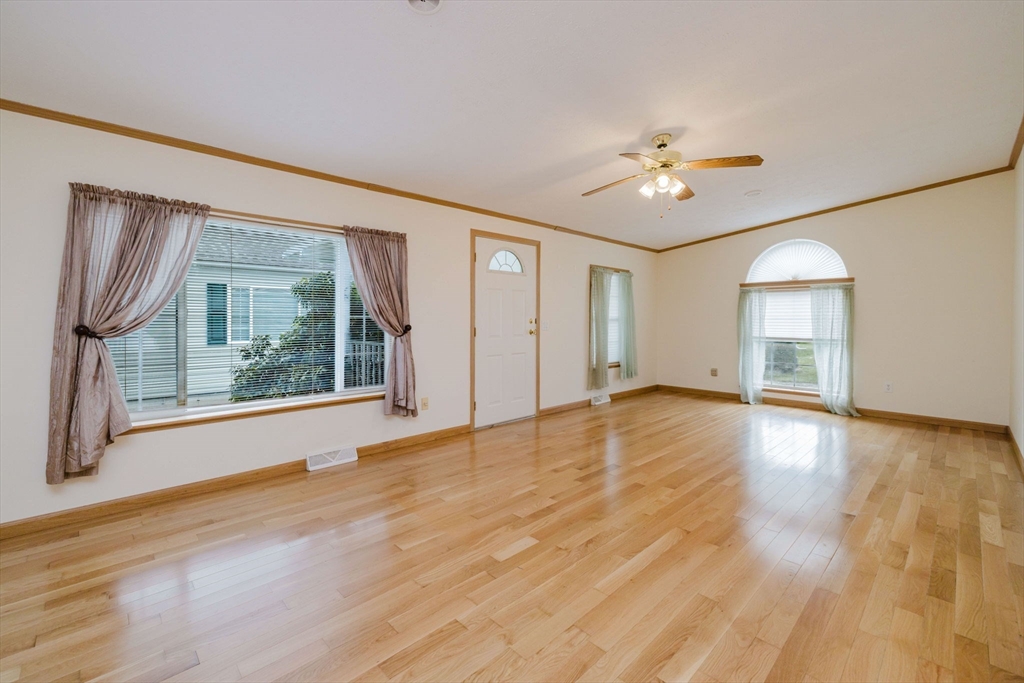 18 Mockingbird Lane Tiverton, RI 02878 - Photo 12 of 32 a view of an empty room with a window and wooden floor