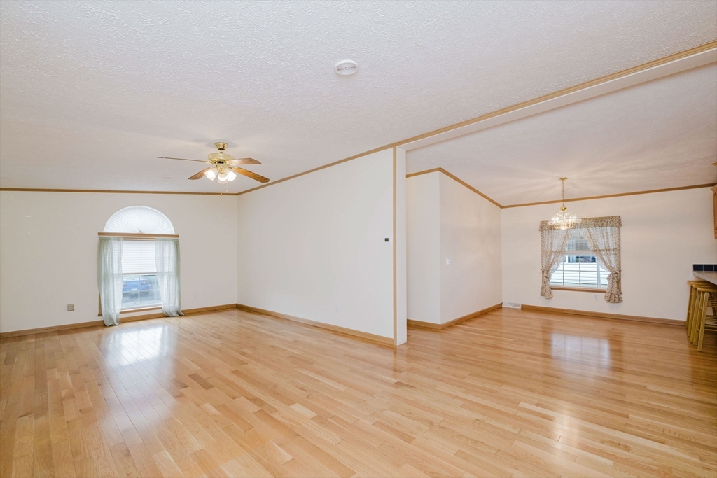 18 Mockingbird Lane Tiverton, RI 02878 - Photo 14 of 32 an empty room with wooden floor and windows