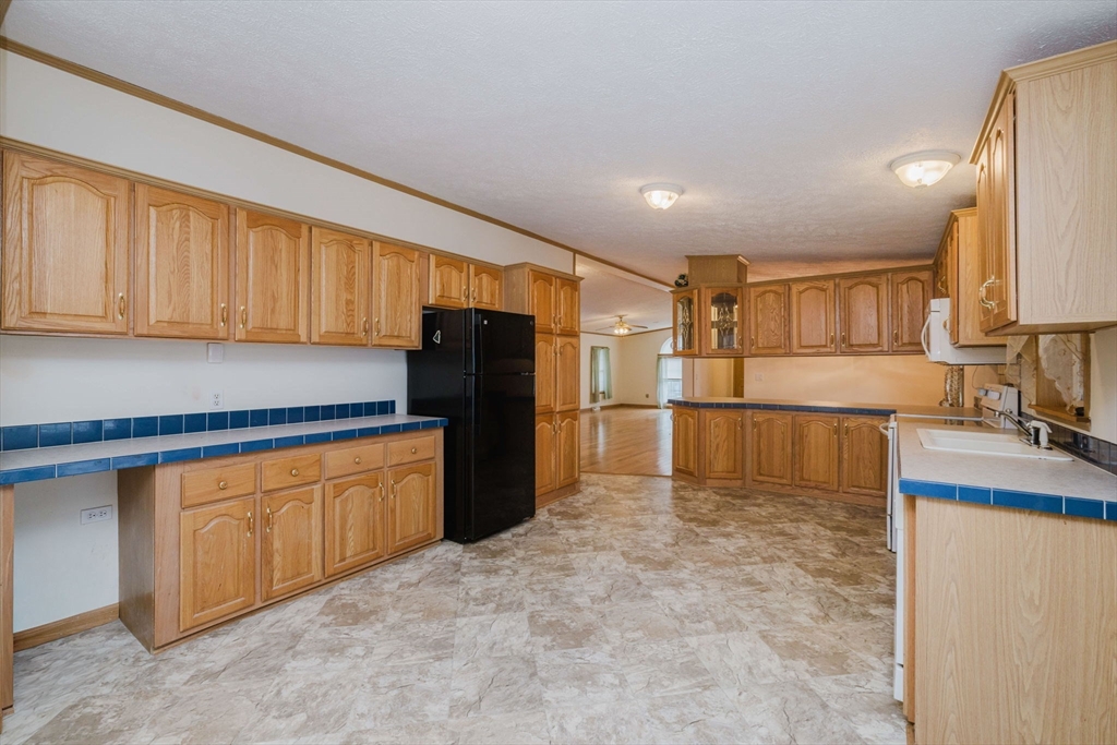 18 Mockingbird Lane Tiverton, RI 02878 - Photo 9 of 32 a kitchen with granite countertop a refrigerator and a sink