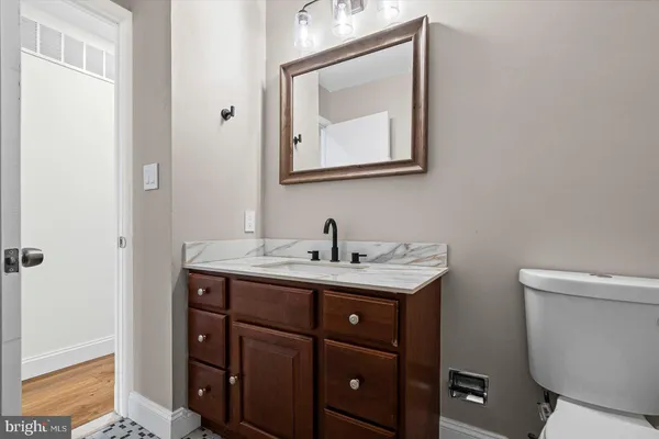 a bathroom with a toilet sink and mirror