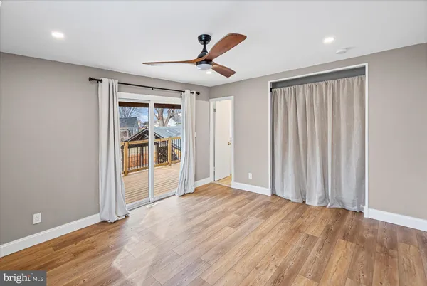 a view of a livingroom with wooden floor and a ceiling fan