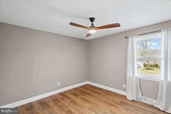 an empty room with window and wooden floor
