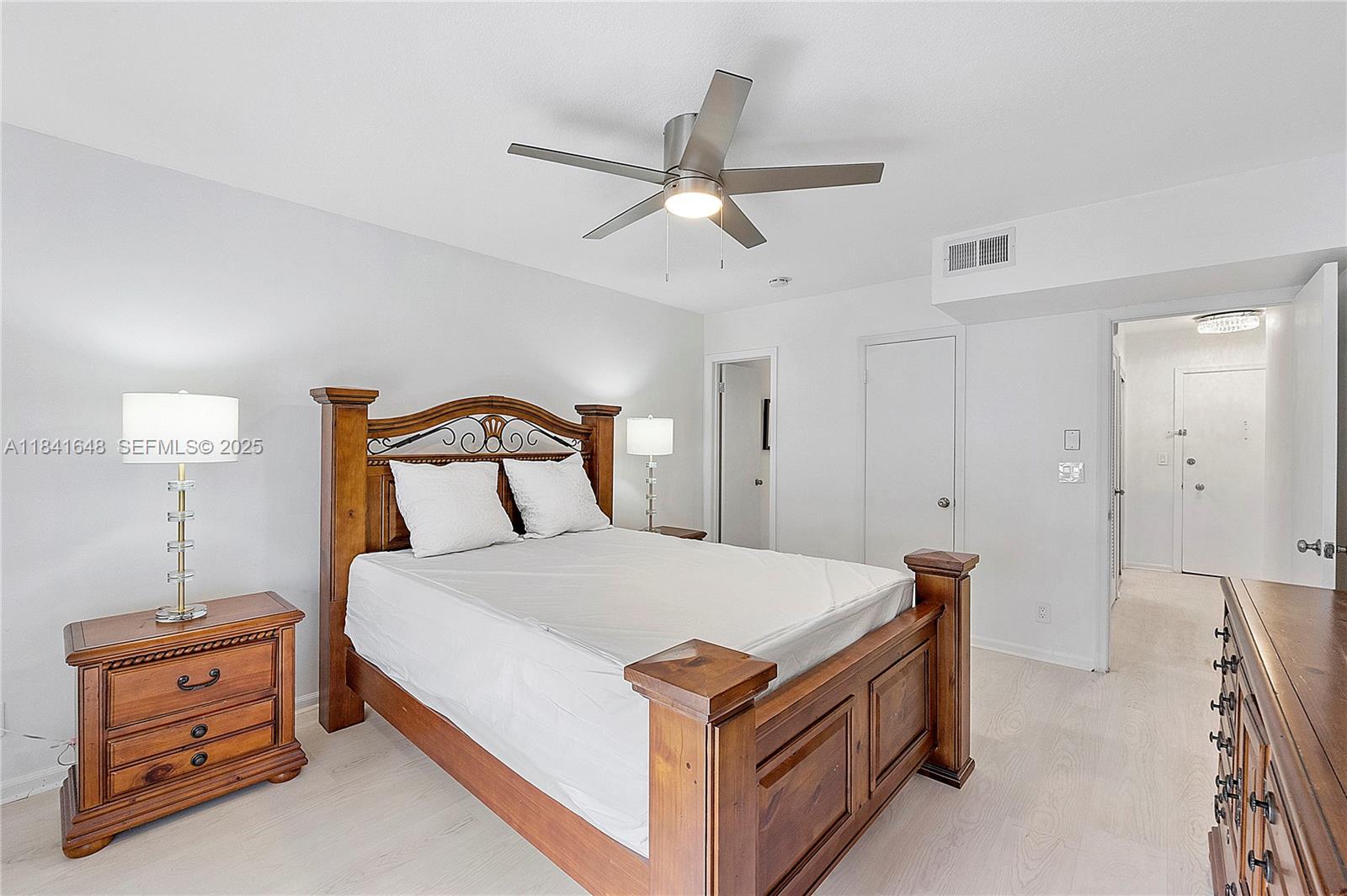 2180 Northeast 67th Street, Unit 728 Fort Lauderdale, FL 33308 - Photo 12 of 49 a bedroom with a bed and a chandelier