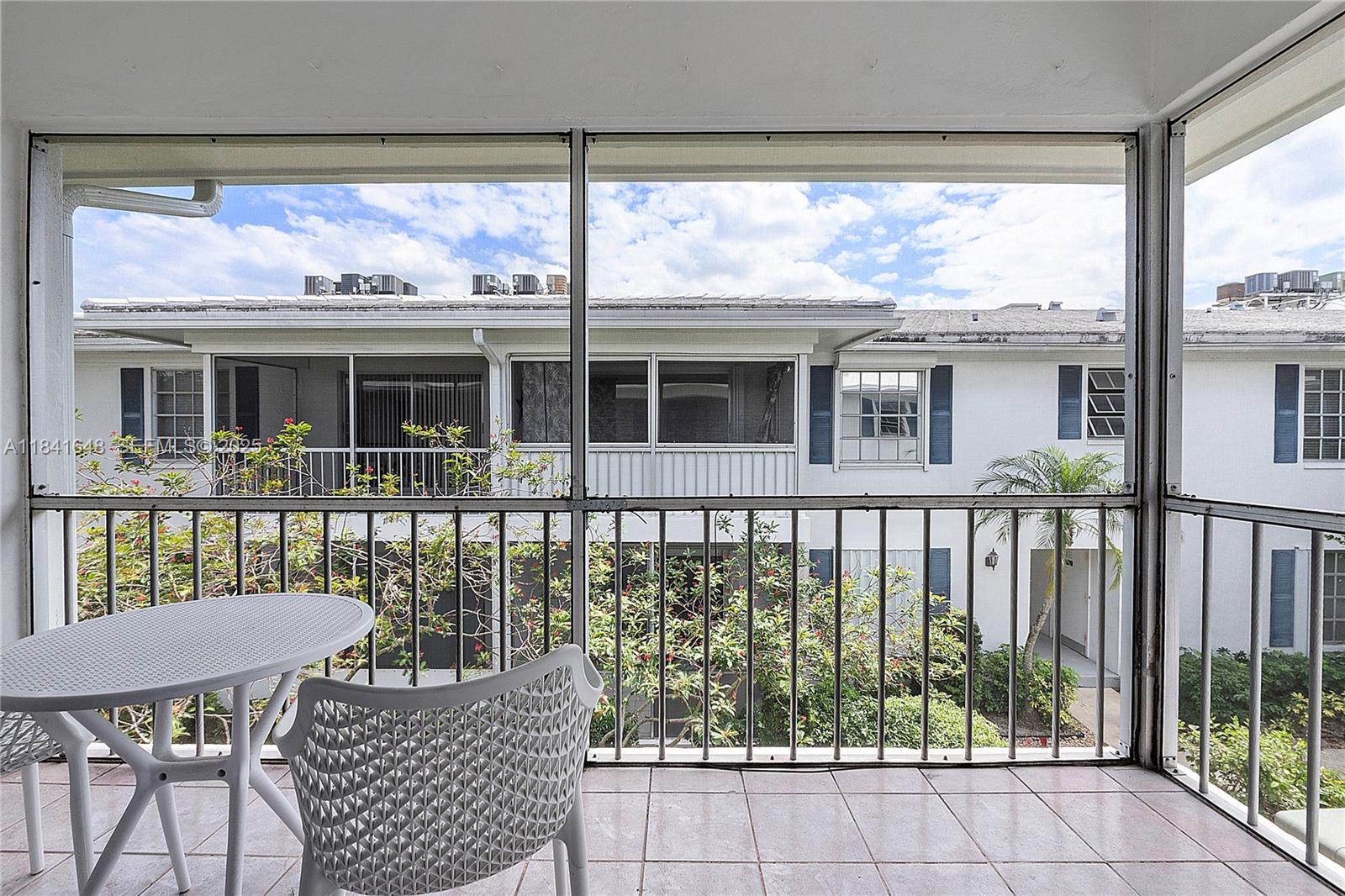 2180 Northeast 67th Street, Unit 728 Fort Lauderdale, FL 33308 - Photo 16 of 49 a view of a chair and table on the deck