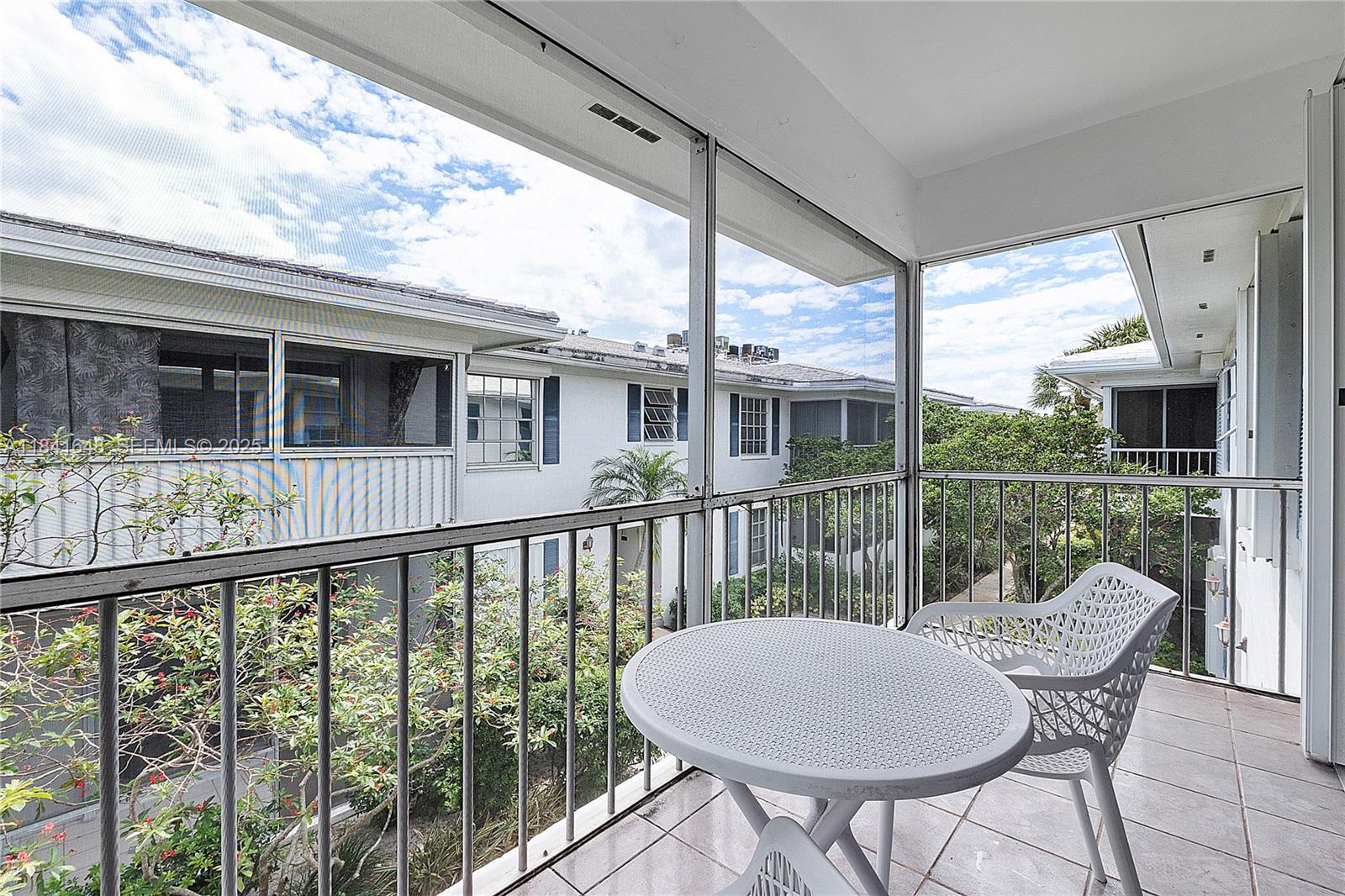 2180 Northeast 67th Street, Unit 728 Fort Lauderdale, FL 33308 - Photo 17 of 49 a view of a balcony with a chair and wooden floor