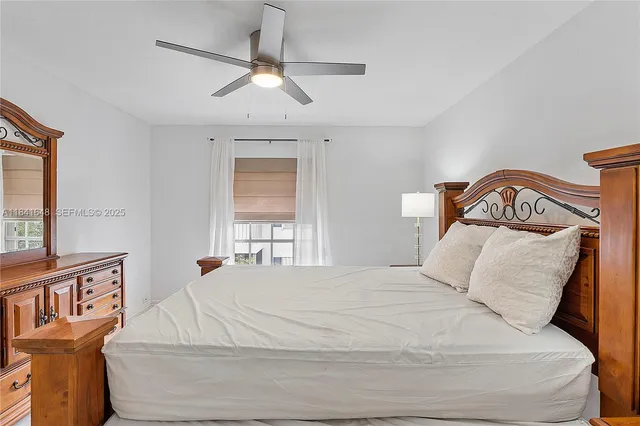 a bedroom with a bed and a large window
