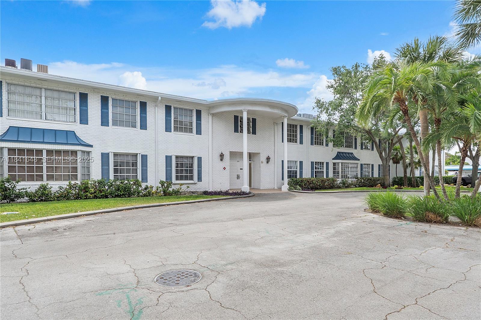 2180 Northeast 67th Street, Unit 728 Fort Lauderdale, FL 33308 - Photo 29 of 49 a front view of a house with a yard and a garage