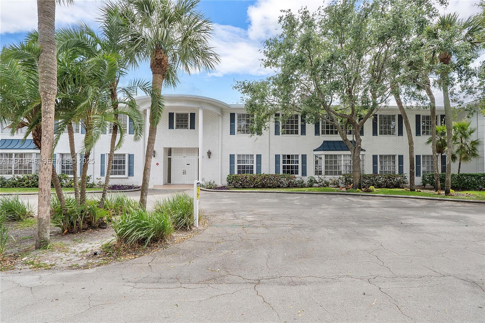 2180 Northeast 67th Street, Unit 728 Fort Lauderdale, FL 33308 - Photo 30 of 49 a front view of a house with a yard and garage