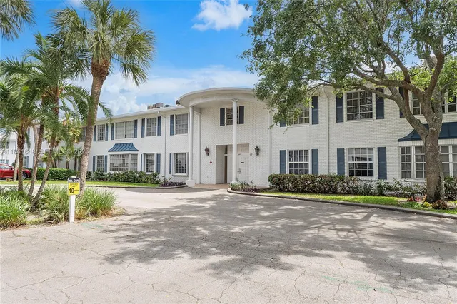 a front view of a house with a yard and potted plants
