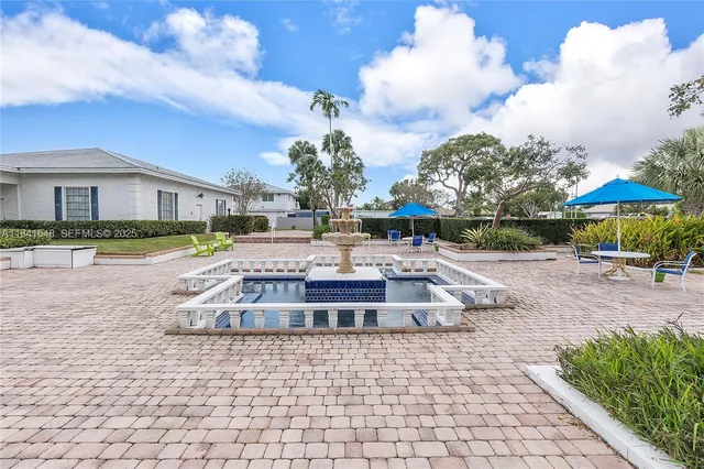 a front view of a house with a yard and fountain