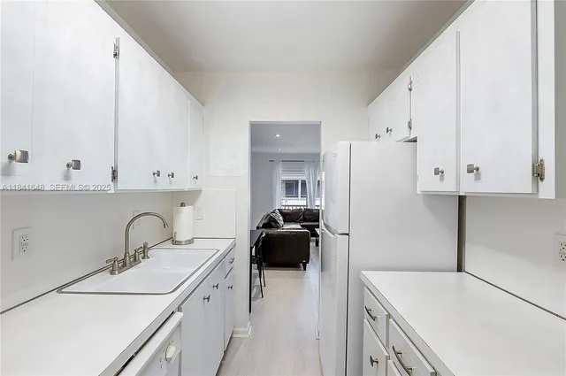 a kitchen with a sink cabinets and white wooden cabinets
