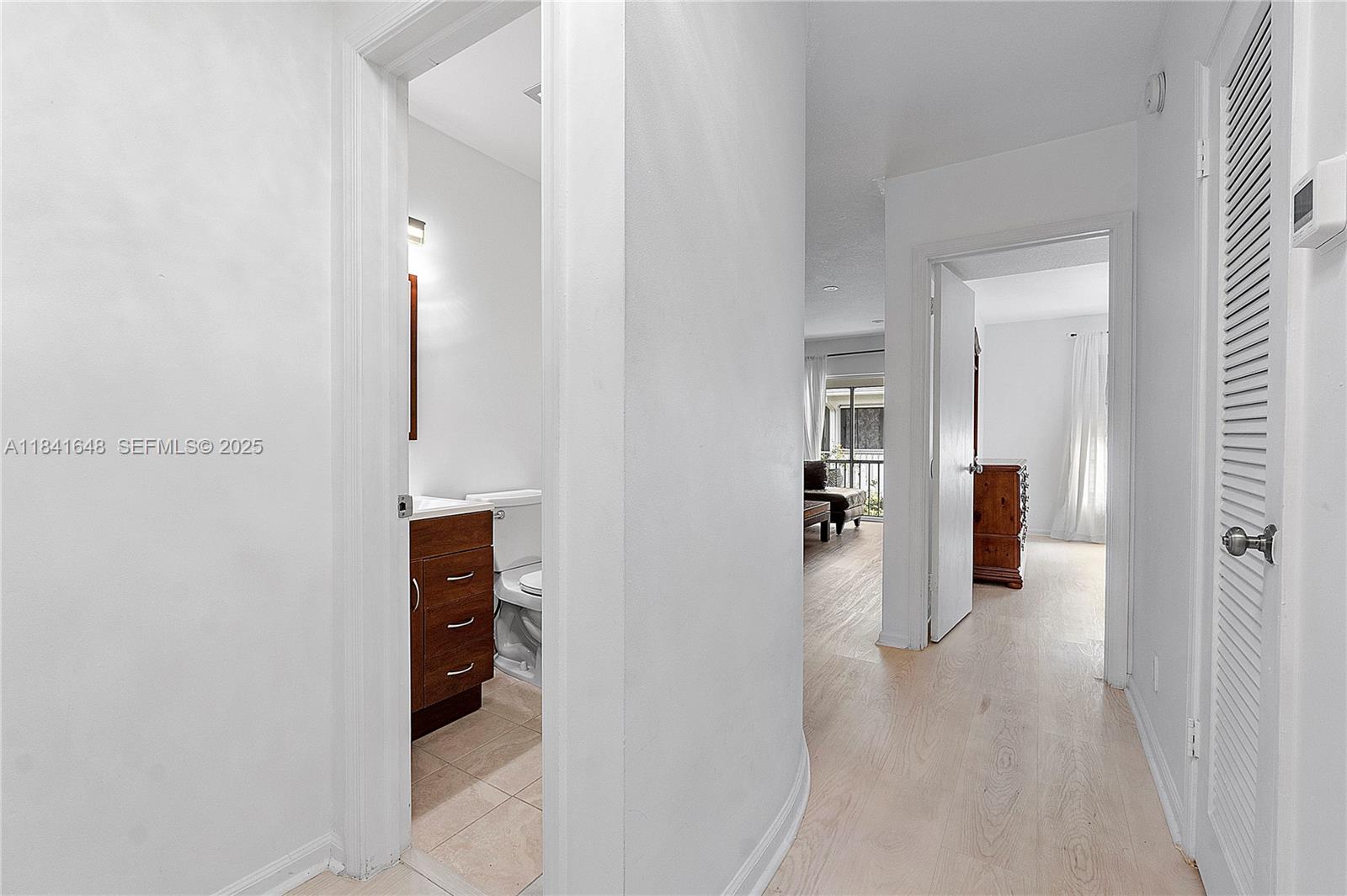 2180 Northeast 67th Street, Unit 728 Fort Lauderdale, FL 33308 - Photo 9 of 49 a view of a hallway with wooden shelves