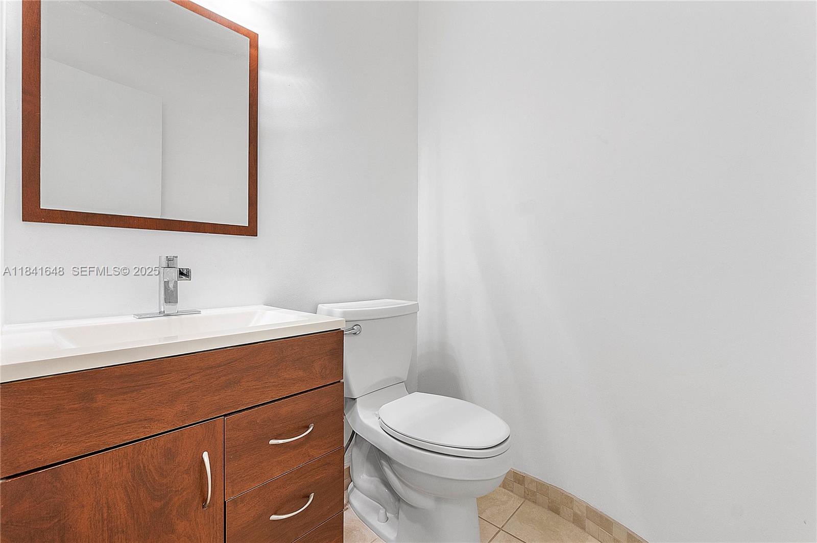 2180 Northeast 67th Street, Unit 728 Fort Lauderdale, FL 33308 - Photo 10 of 49 a bathroom with a sink a toilet and mirror