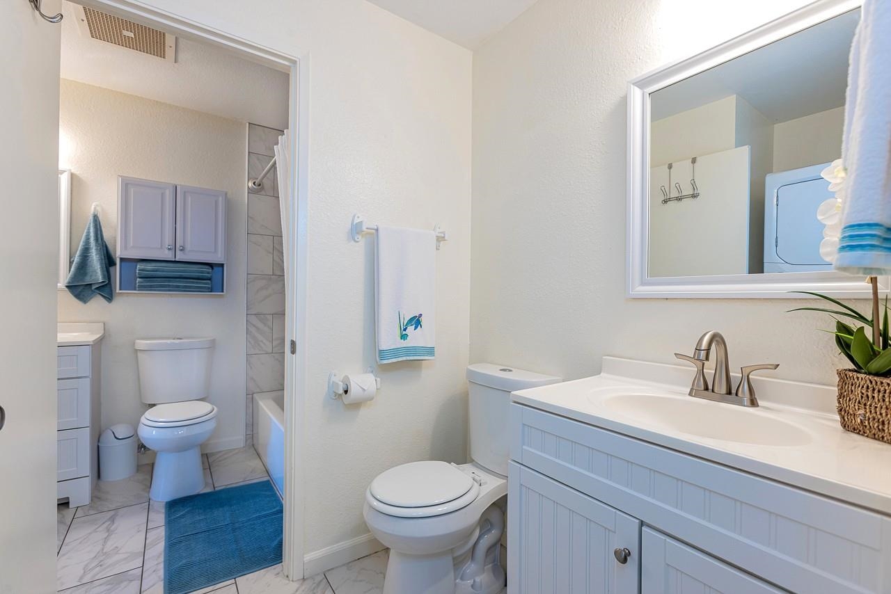 140 Uwapo Road, Unit 55205 Kihei, HI 96753 - Photo 16 of 31 a bathroom with a sink toilet a mirror and vanity