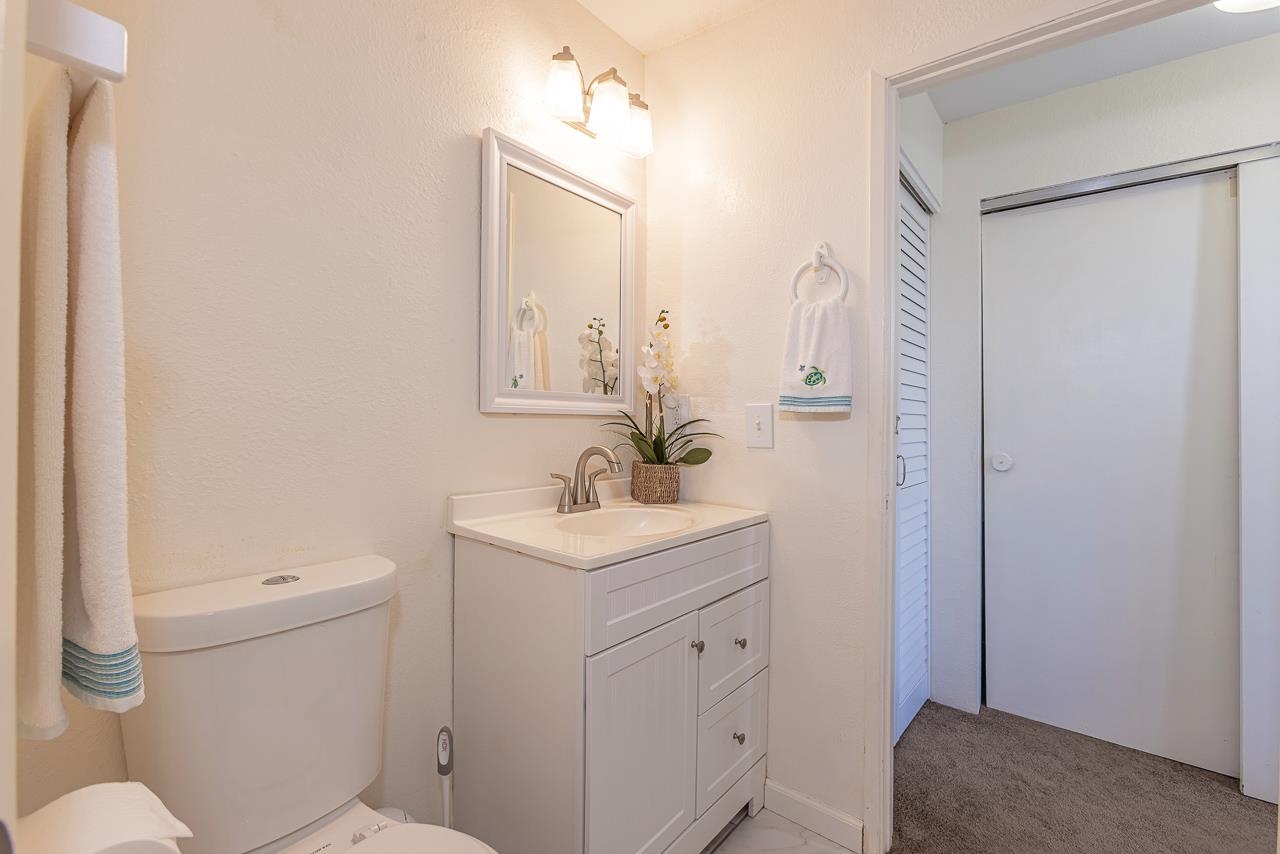 140 Uwapo Road, Unit 55205 Kihei, HI 96753 - Photo 20 of 31 a bathroom with a sink a toilet a mirror and vanity