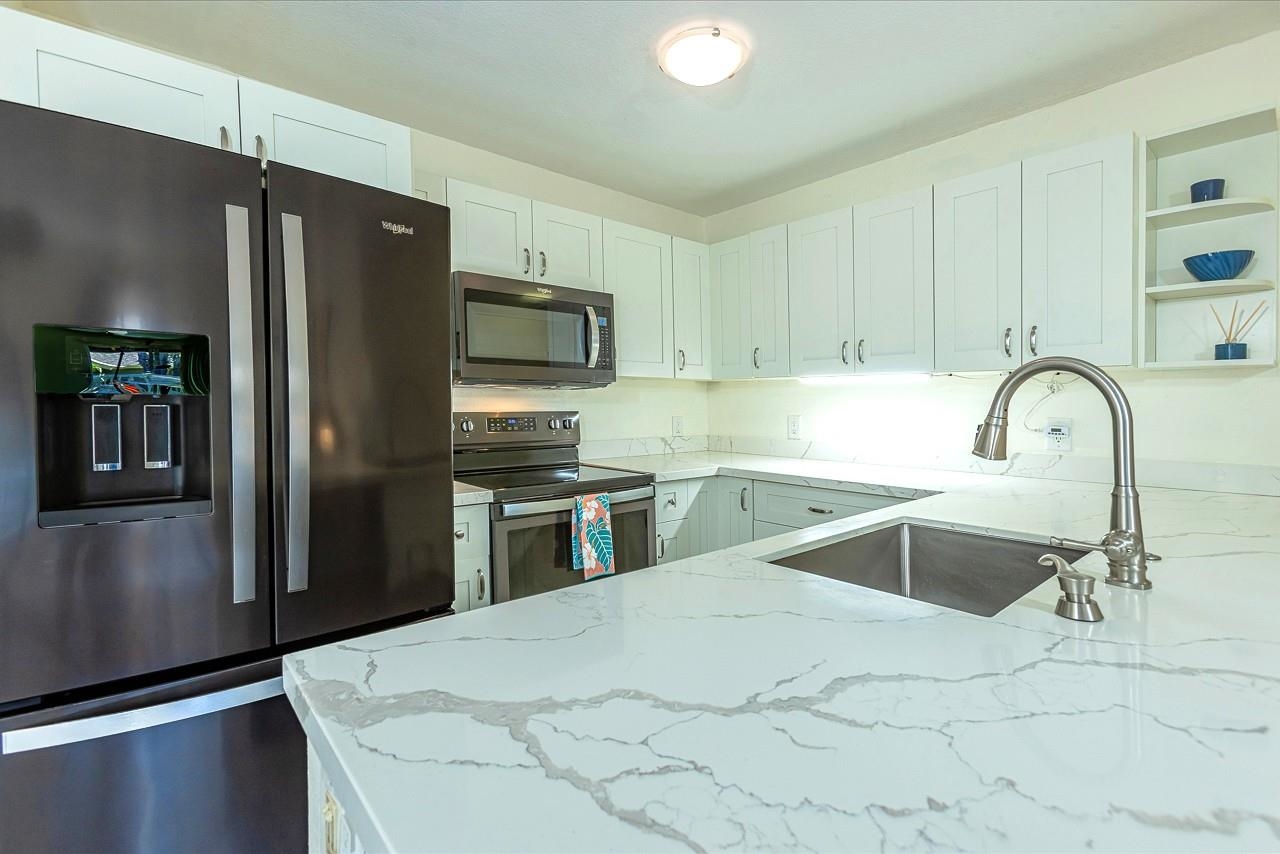 140 Uwapo Road, Unit 55205 Kihei, HI 96753 - Photo 5 of 31 a kitchen with granite countertop a refrigerator and a sink