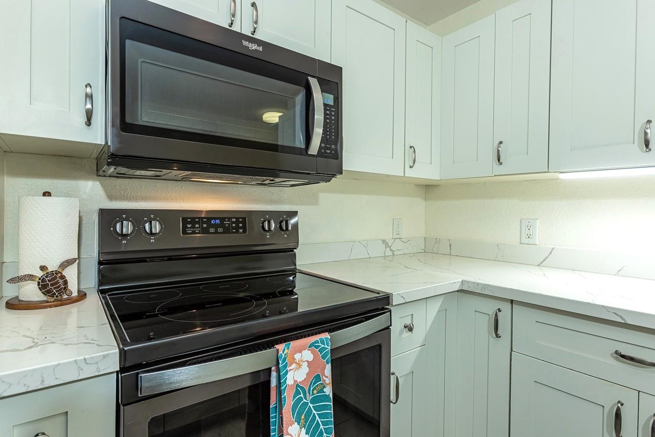 140 Uwapo Road, Unit 55205 Kihei, HI 96753 - Photo 6 of 31 a kitchen with a stove microwave and sink