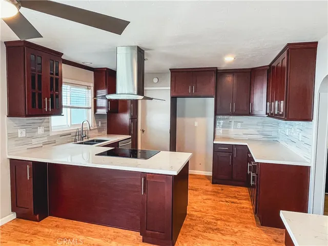 a kitchen with stainless steel appliances kitchen island granite countertop a sink refrigerator and cabinets