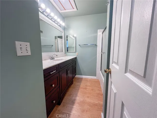 a spacious bathroom with a double vanity sink a mirror and a shower