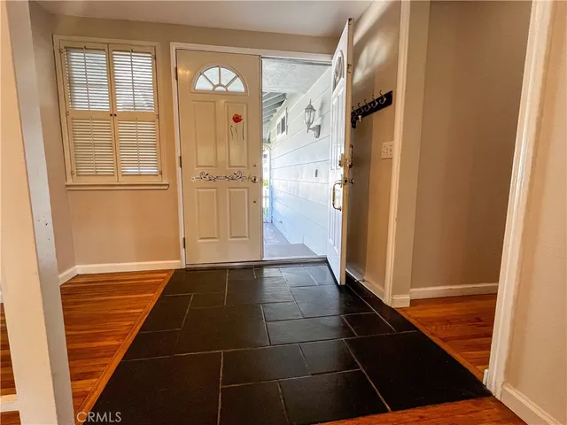a view of a hallway with wooden floor and a cabinet