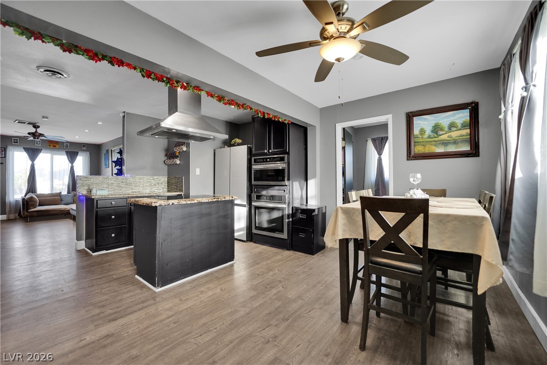 2221 Englestad Street North Las Vegas, NV 89030 - Photo 12 of 32 An open-concept living space integrates a well-appointed kitchen with dining, featuring granite counters.