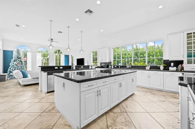 a large white kitchen with a large window and stainless steel appliances