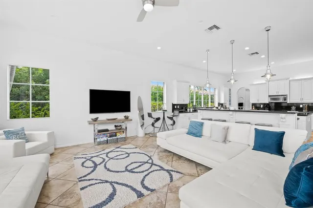 a living room with furniture a flat screen tv and a large window