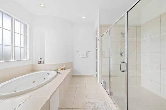 a bathroom with a tub a sink and a window