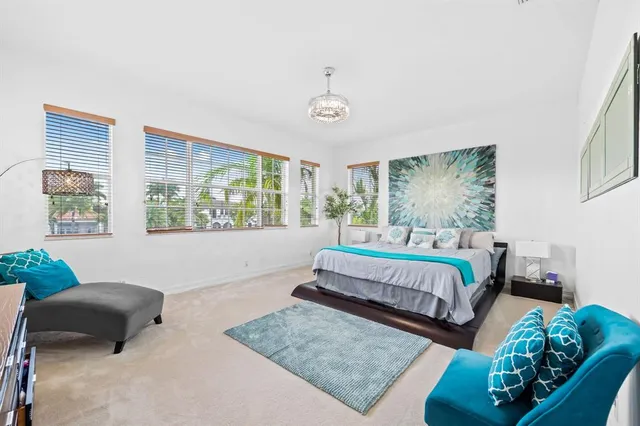 a bedroom with a bed a large window and a flat screen tv