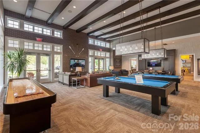 a living room with furniture a pool table and a large window