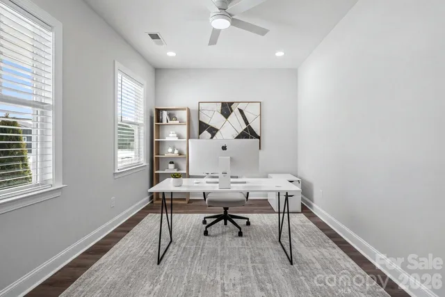 a view of a workspace with furniture and a window