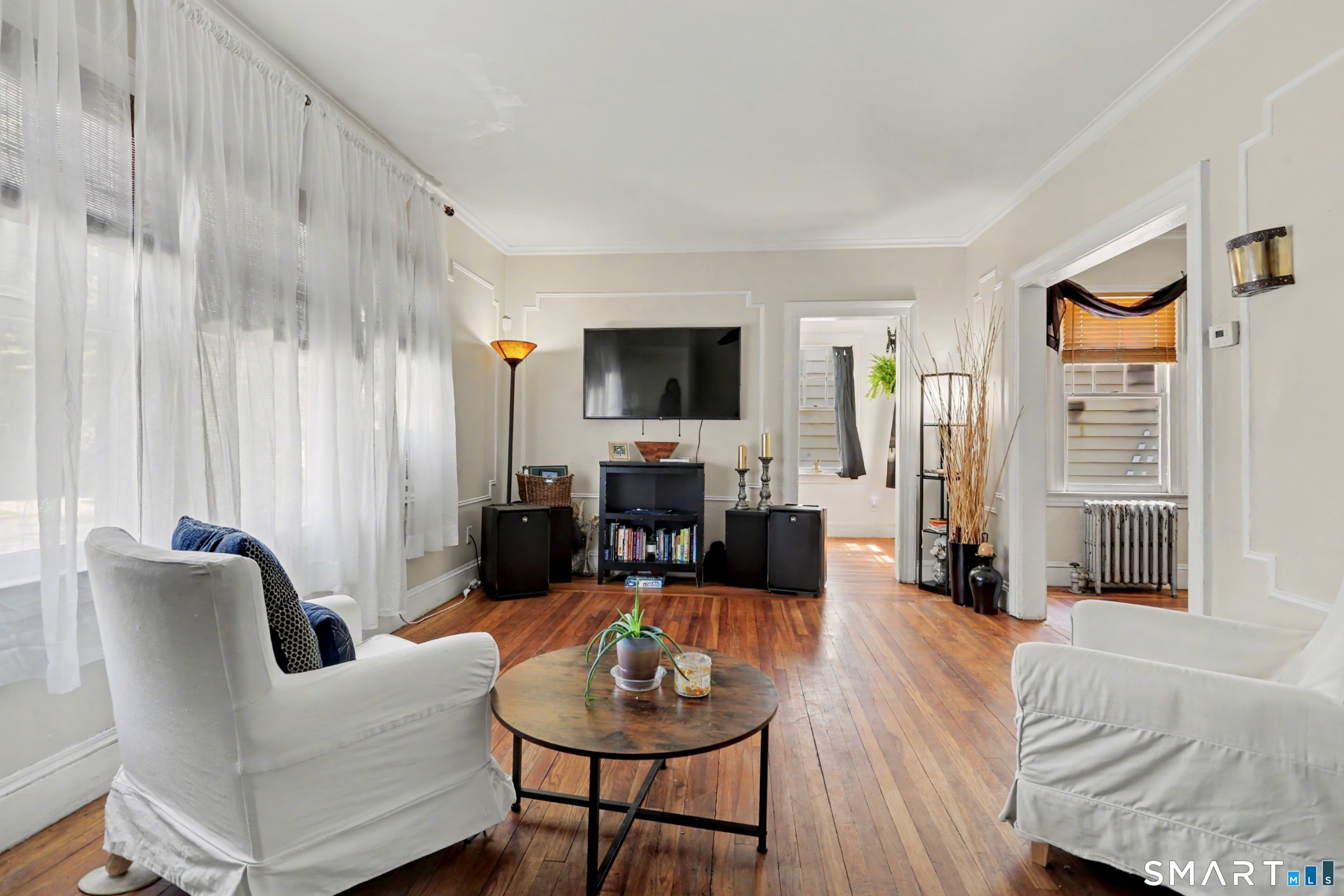 94 2nd Street Hamden, CT 06514 - Photo 4 of 31 a living room with furniture a large window and a flat screen tv
