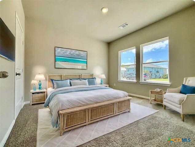 a spacious bedroom with a bed couch and a window