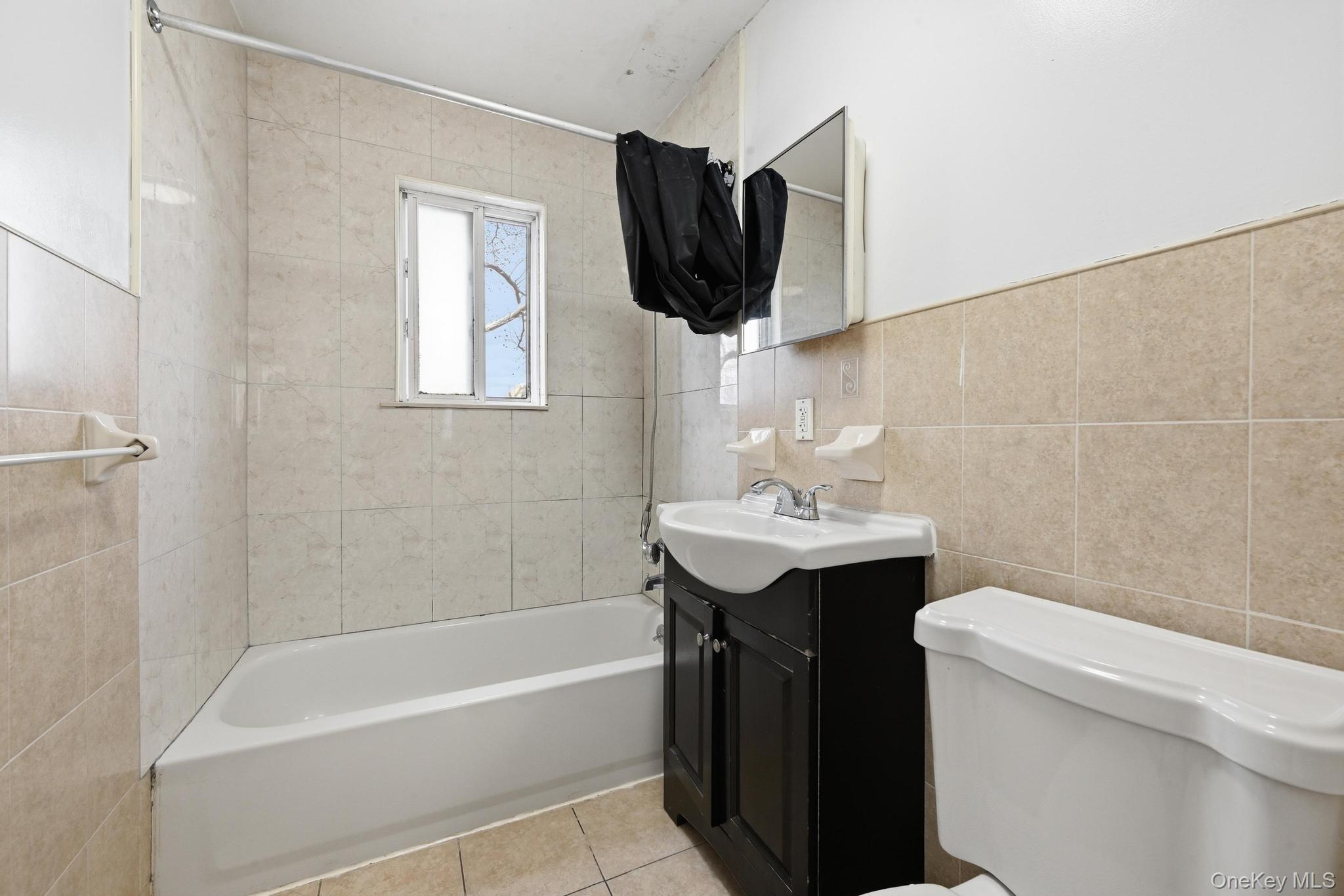 61-16 161 Street Queens, NY 11365 - Photo 14 of 22 a bathroom with a sink a toilet and bathtub