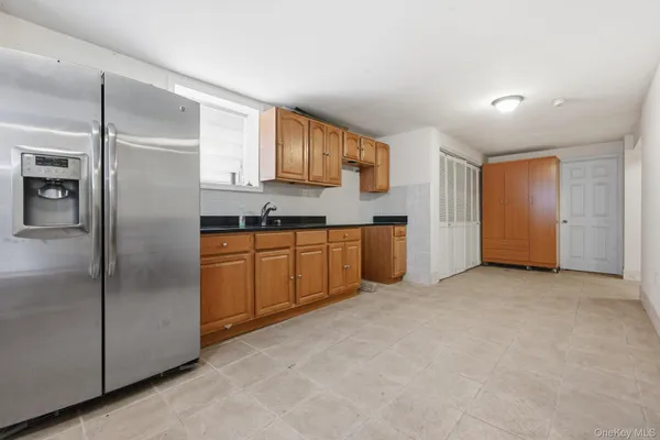 a view of a kitchen with stainless steel appliances granite countertop a refrigerator and a sink