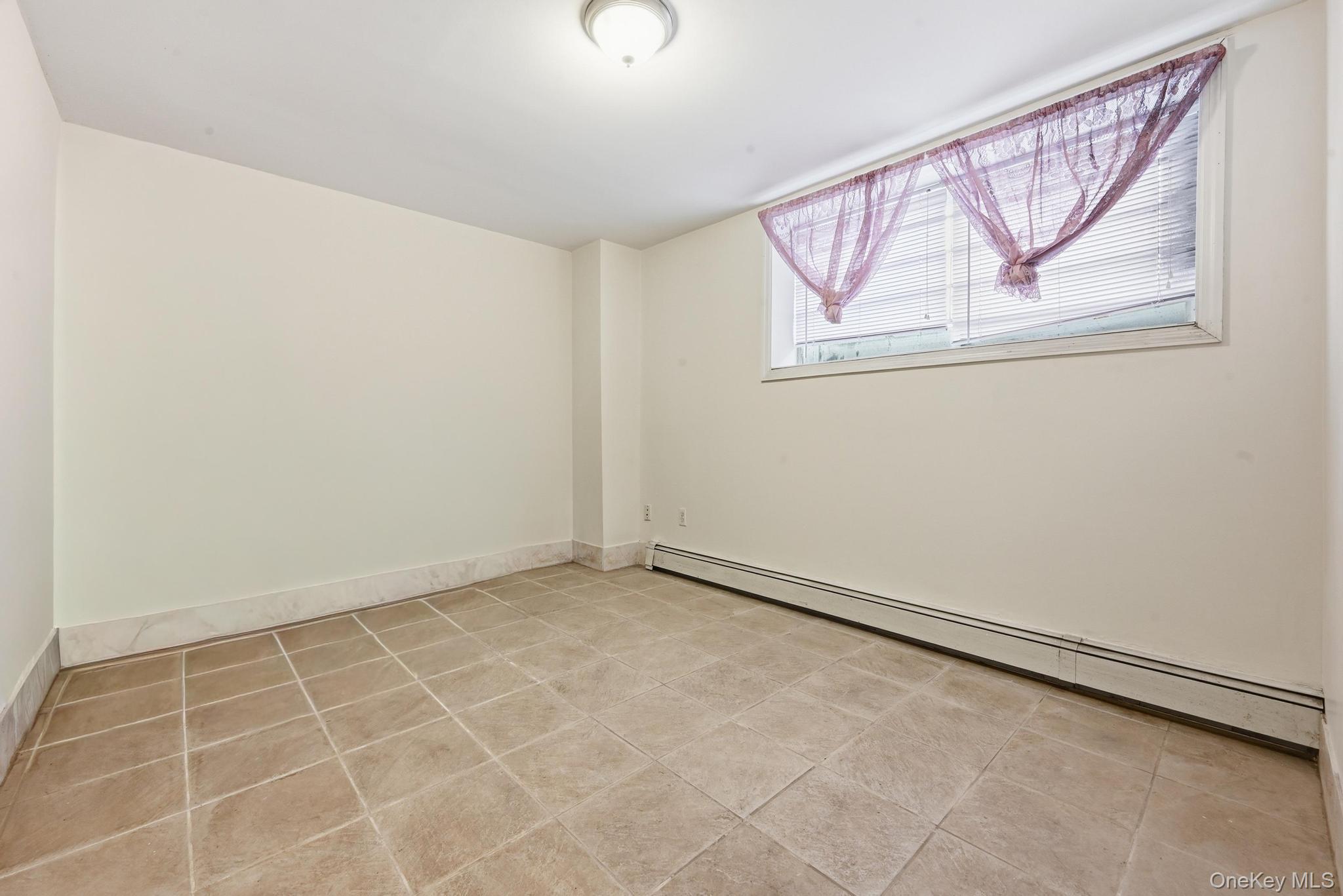 61-16 161 Street Queens, NY 11365 - Photo 19 of 22 an empty room with a window