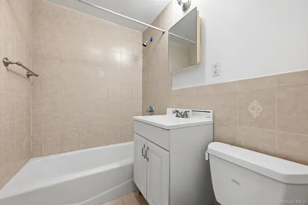 a view of bathroom with a sink and mirror with toilet