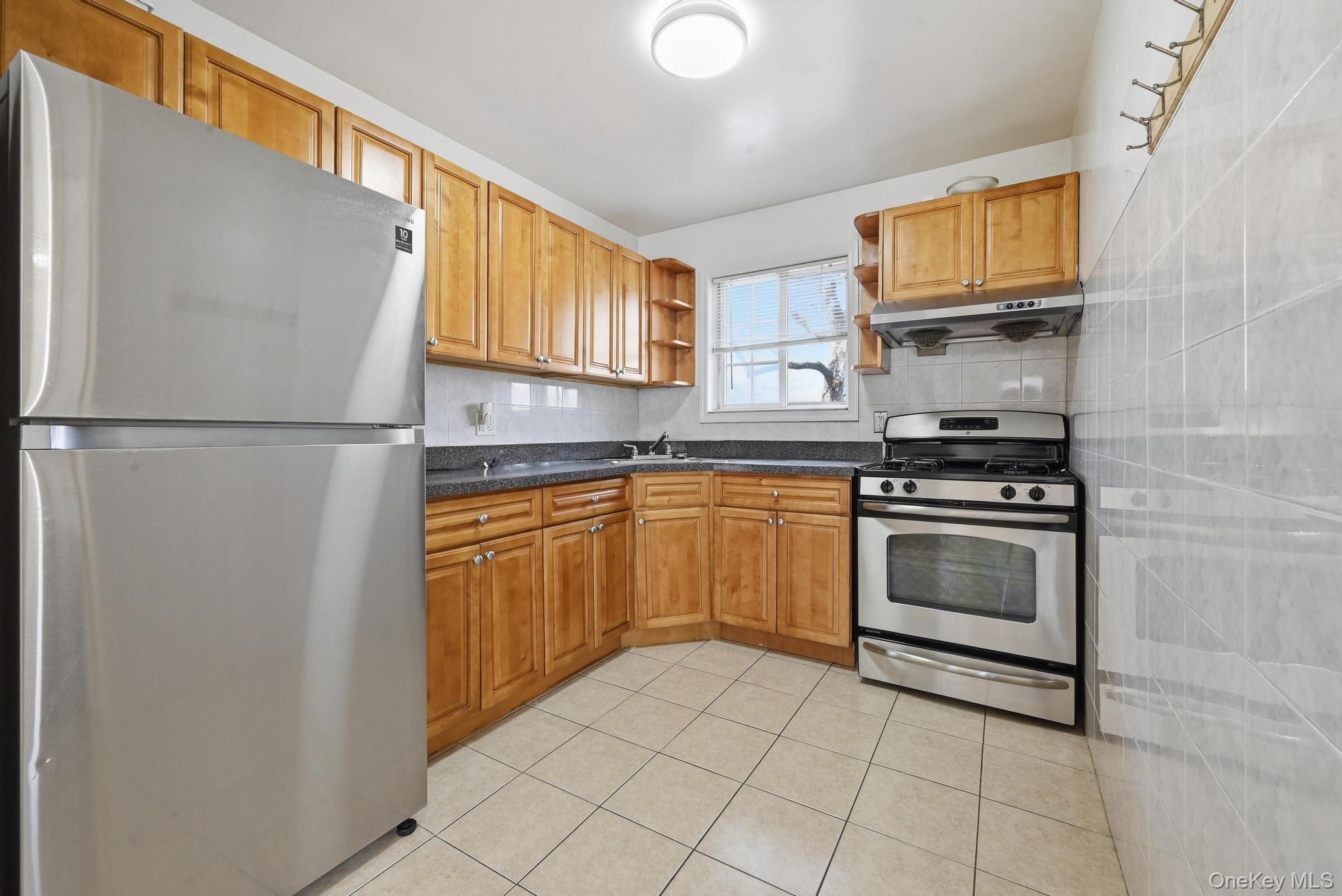 61-16 161 Street Queens, NY 11365 - Photo 9 of 22 a kitchen with stainless steel appliances granite countertop a refrigerator sink and stove