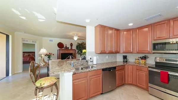 a kitchen with kitchen island granite countertop a sink cabinets and stainless steel appliances
