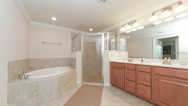 a bathroom with a tub a double vanity sink and mirror